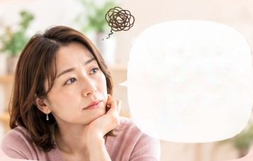 不安そうな表情で考える女性